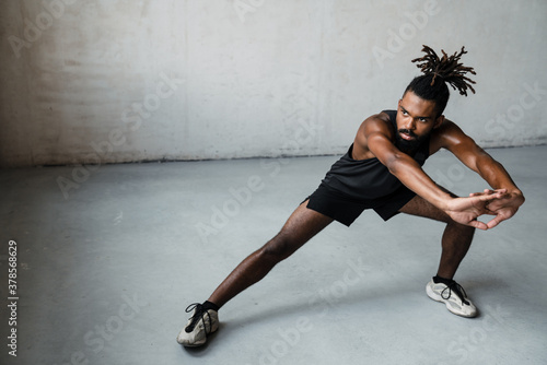 Image of african american sportsman doing exercise while working out