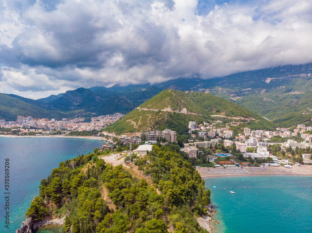 Beautiful view from sea to Budva coast and resort town of Becici on background of mountains, Montenegro. Drone aerial photo
