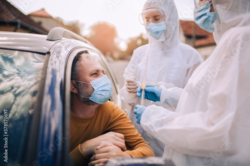 Doctors in a protective suit taking swab from a person to test for possible coronavirus infection