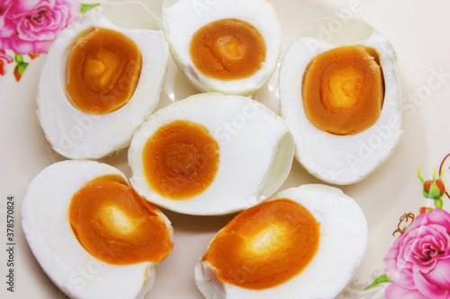 Salt eggs cut in half with orange yolks and eggs white in white dish