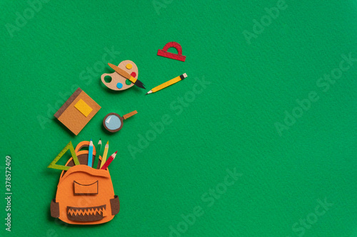 Funny school illustration. Stationery supplies such as schoolbag, notebook, magnifier, protractor, pencil, watercolor on green background. Back to school concept.  photo