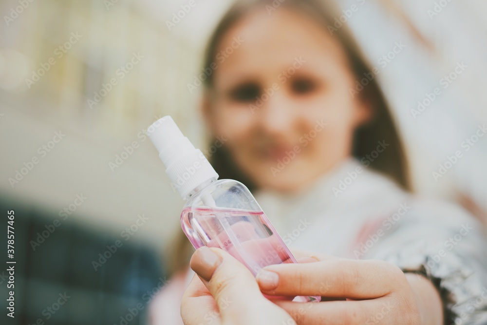 Mom give to her daughter hand sanitizer, gel for hand. Child holding sanitizer. Covid 19 Mom give to her daughter hand sanitizer, gel for hand. Child holding sanitizer. Covid 19
