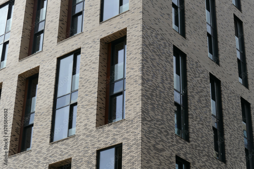Exterior of a high-rise multi-story apartment building - facade, windows and balconies. Exterior of a high-rise multi-story apartment building - facade, windows and balconies.