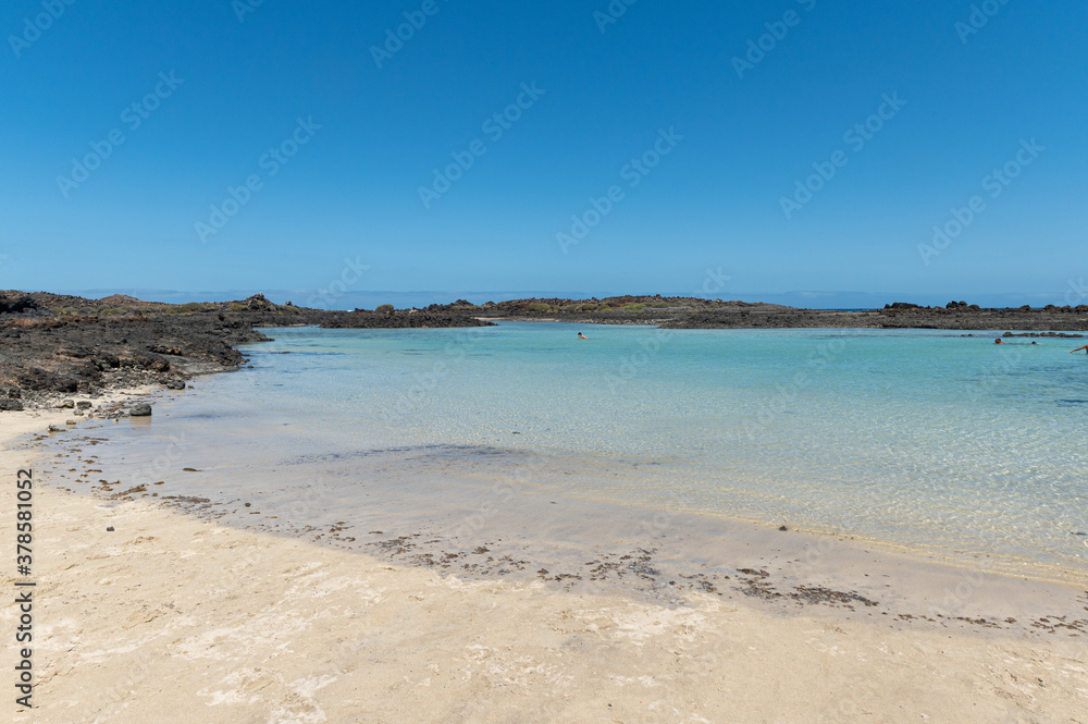 View of a beach with emerald water and dark volcanic rocks in Lobos island (Canary islands)