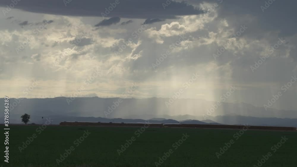 Sun beams cutting through intense clouds over Imperial Valley fields in southern California Sun beams cutting through intense clouds over Imperial Valley fields in southern California