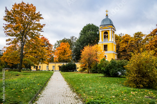 The bell tower of the Annunciation Church in Saint-Petersburg, Russia, in the autumn among the colorful trees photo