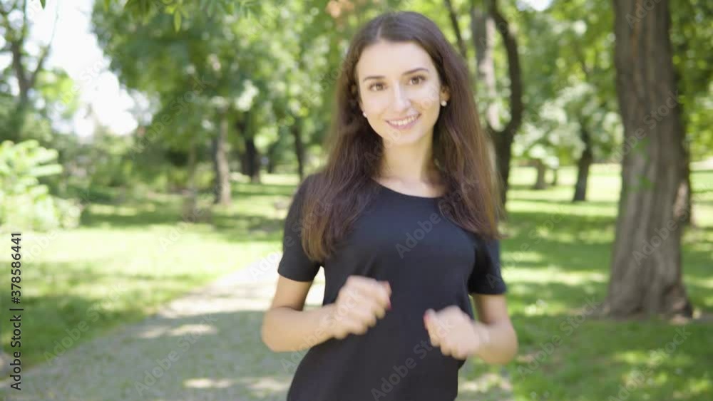 A young Turkish woman dances and smiles at the camera in a park on a sunny day A young Turkish woman dances and smiles at the camera in a park on a sunny day