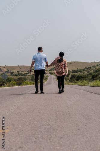 A man and a woman walking on a highway