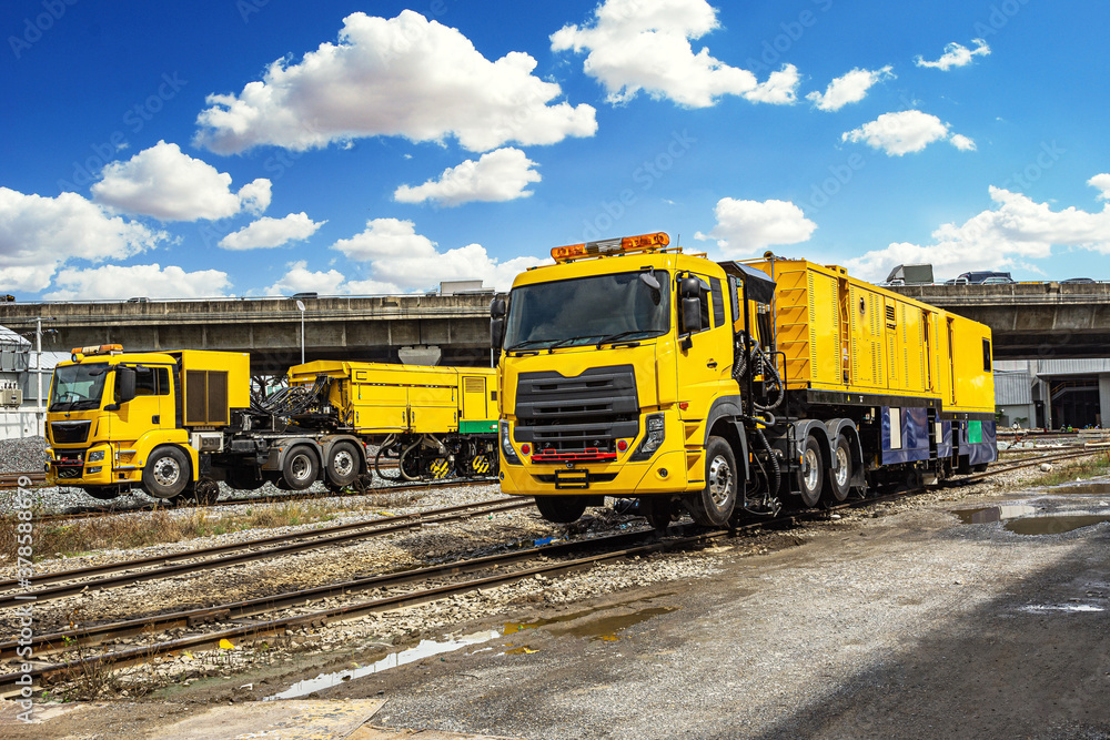 The Modern Yellow rails maintaining machine car stand by for making maintainance the rail with blue sky.