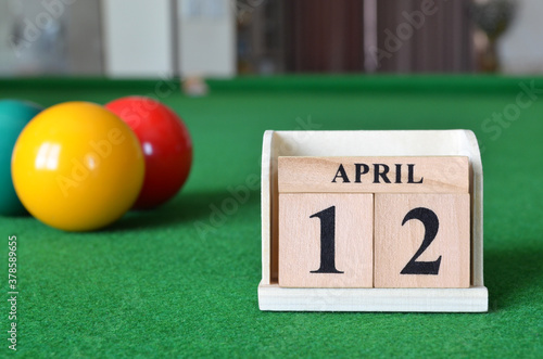 April 12, number cube with balls on snooker table, sport background. photo