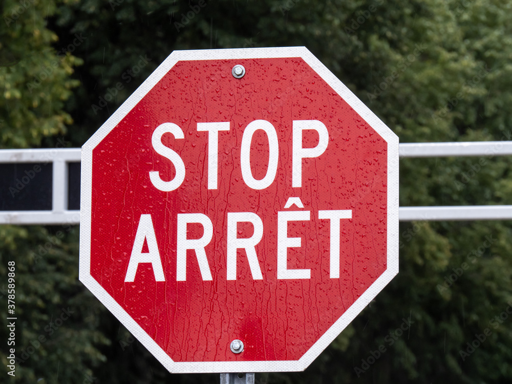 A bilingual English and French stop sign on a gate in Canada A bilingual English and French stop sign on a gate in Canada