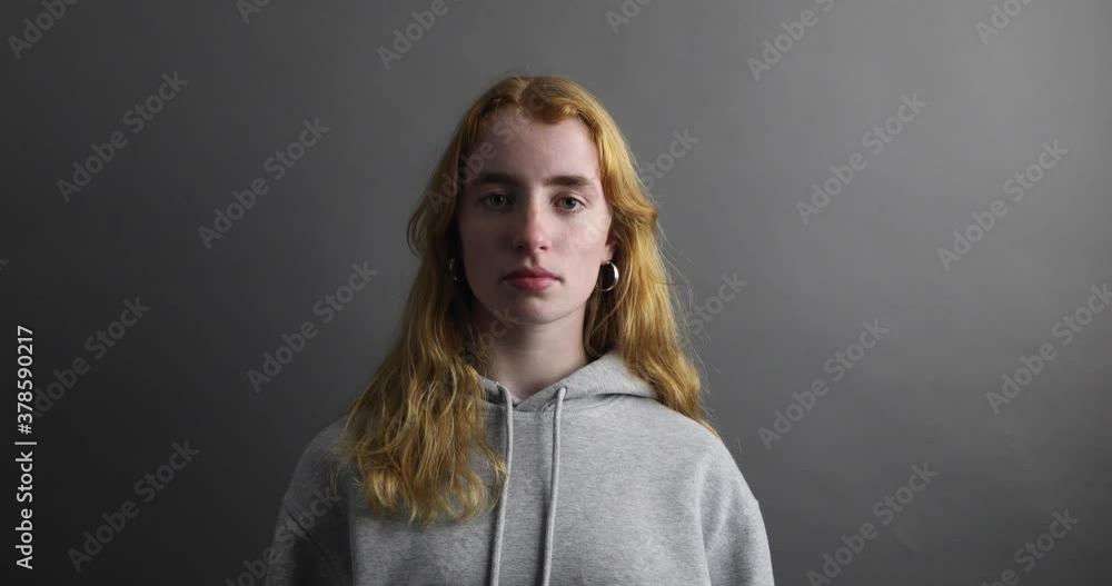 junge Frau blickt traurig und bläst eine Luftschlange Richtung Kamera junge Frau blickt traurig und bläst eine Luftschlange Richtung Kamera