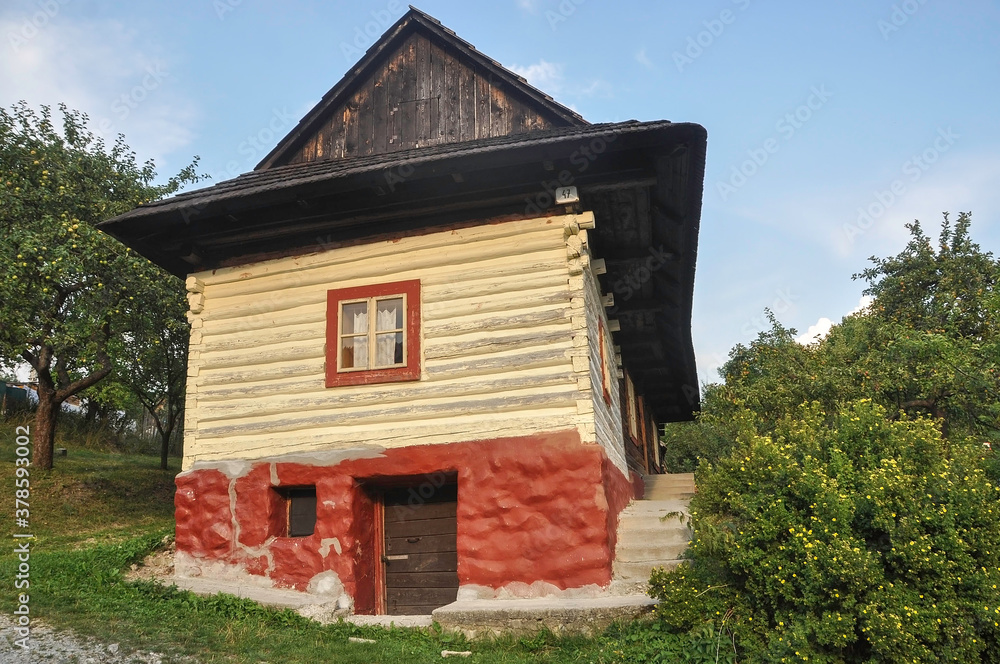 VLKOLINEC, SLOVAKIA, EUROPE, SUMMER 2015. Beautiful rural house with traditional Slovak vanilla painted wooden architecture in the Unesco heritage village of Vlkolinec. VLKOLINEC, SLOVAKIA, EUROPE, SUMMER 2015. Beautiful rural house with traditional Slovak vanilla painted wooden architecture in the Unesco heritage village of Vlkolinec.