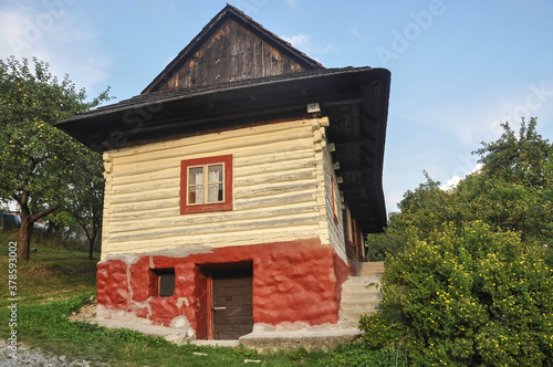 VLKOLINEC, SLOVAKIA, EUROPE, SUMMER 2015. Beautiful rural house with traditional Slovak vanilla painted wooden architecture in the Unesco heritage village of Vlkolinec. © LourPhoto