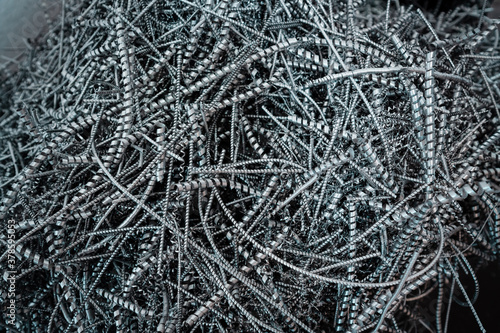 A pile of metal spirals as burr waste in metal processing.