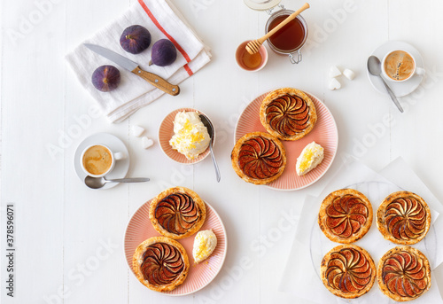 Homemade puff pastry fig tarts with vanilla and honey mascarpone - Gordon Ramsey recipe. White wooden table background. © arazu
