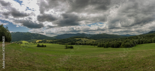 Fototapeta Naklejka Na Ścianę i Meble -  Panorama view with meadows and pasture land and gray clouds near Runina village
