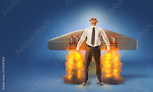 businessman with wings and flares on his back with flames and smoke. photo