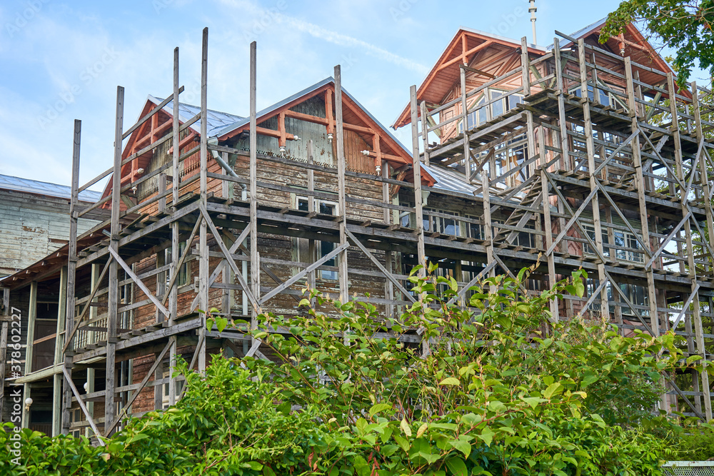 Old wooden building under renovation with scaffolding around it. 
