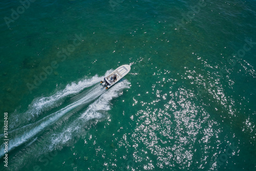 Drone view of a boat sailing. Top view of a white boat sailing to the blue sea. Motor boat in the sea. Travel - image. © Berg