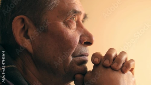 Senior man at home, looking up, praying prayer, thinking. Portrait, closeup, 4K UHD.