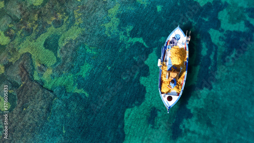 Photos Aerial drone top down photo of traditional fishing boat anchored in small pictur