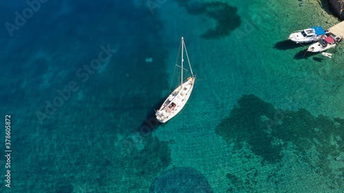 Aerial drone photo of beautiful sailboat anchored in tropical exotic island bay resembling a blue lagoon