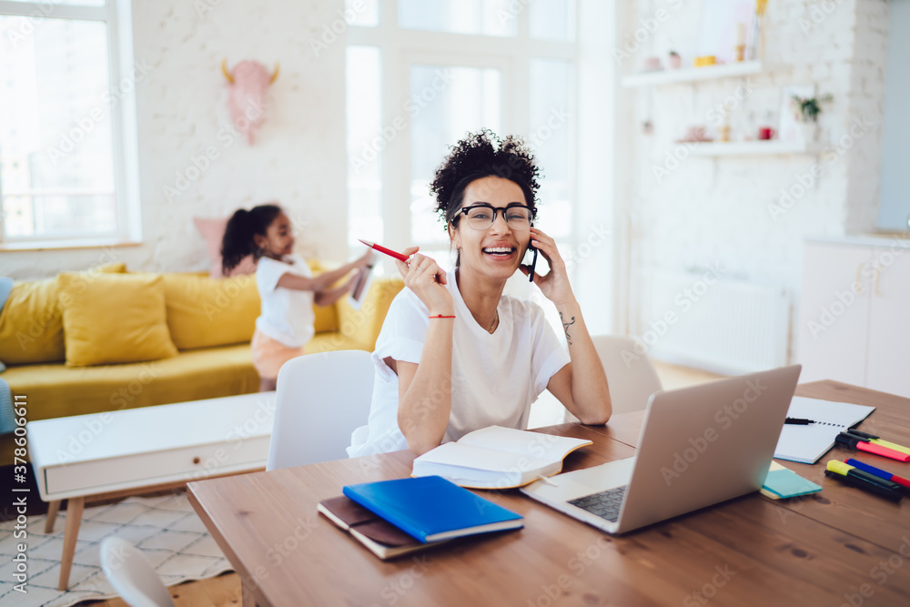 Happy black lady speaking on smartphone near kid Happy black lady speaking on smartphone near kid