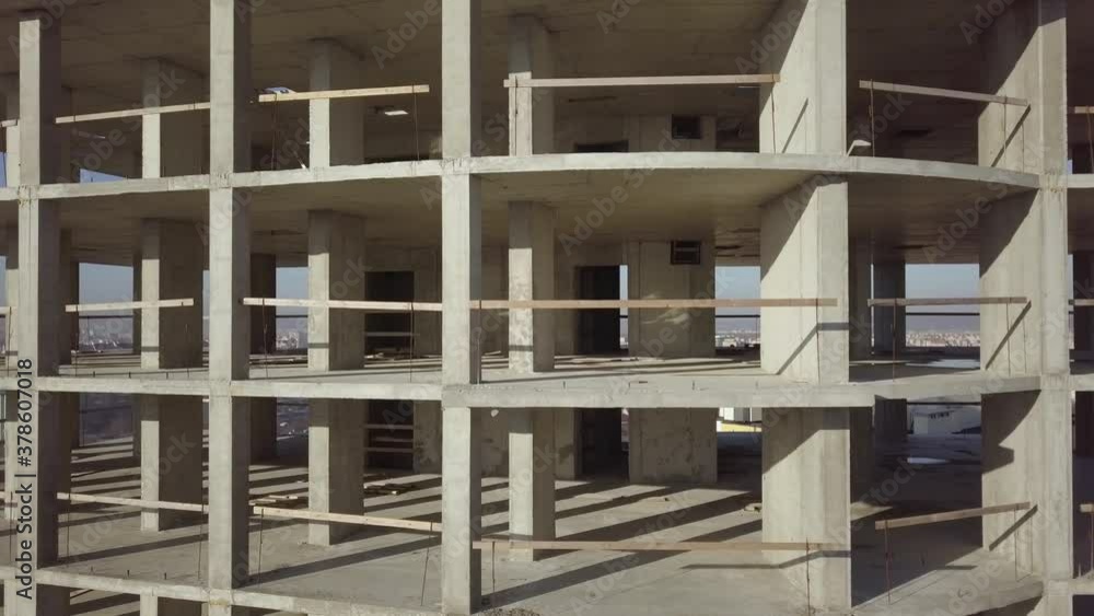 Aerial view of concrete frame of tall apartment building under construction in a city.
Aerial view of concrete frame of tall apartment building under construction in a city.