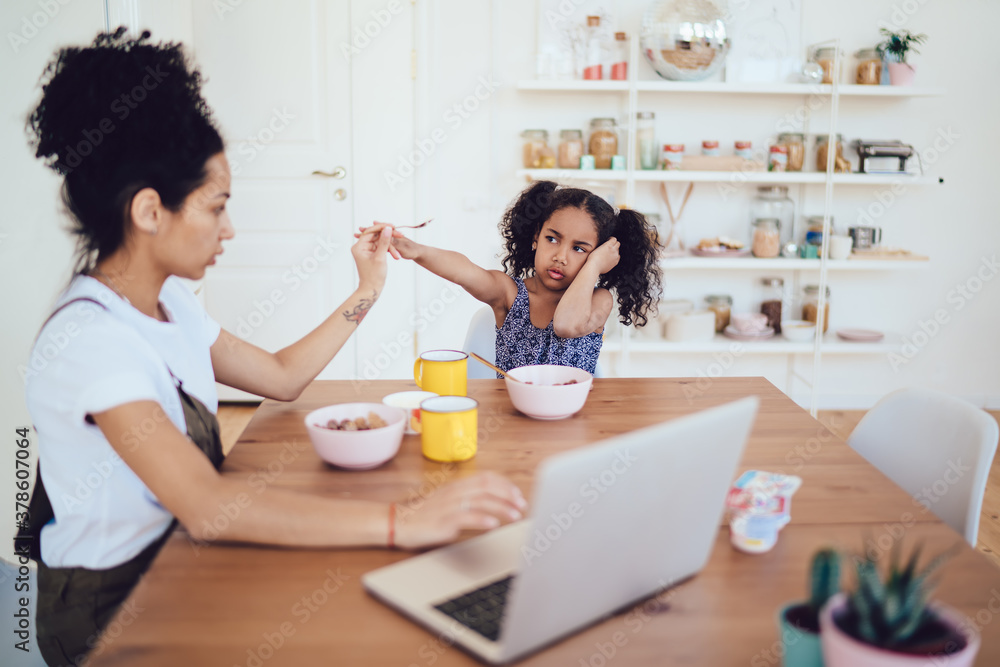 Mother trying to feed daughter at home Mother trying to feed daughter at home