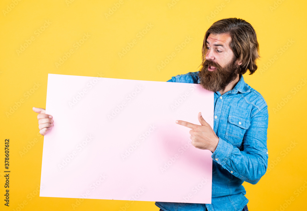 Its happening here. empty place for copy space. need help. bearded man holding placate. wanted. empty paper for your information. barber concept. surprised hipster with beard at paper sheet Its happening here. empty place for copy space. need help. bearded man holding placate. wanted. empty paper for your information. barber concept. surprised hipster with beard at paper sheet