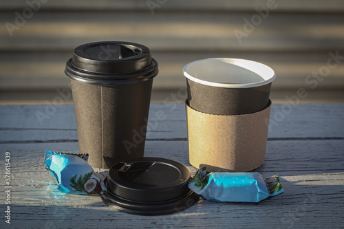 Coffee in disposable cups with sweets on a street bench on a clear day