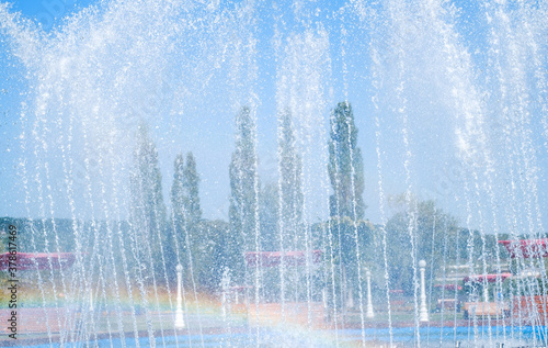 artesian fountain on blue sky with rainbow