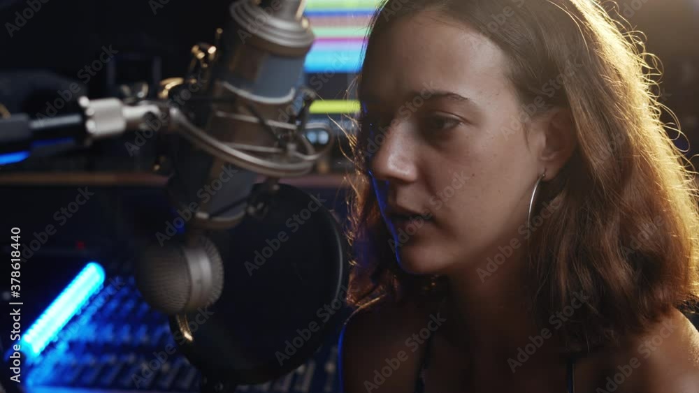 Voice over recording. Professional profiles. Caucasian woman recording podcast. An intelligent brunette female person records her voice. Voice over recording. Professional profiles. Caucasian woman recording podcast. An intelligent brunette female person records her voice.