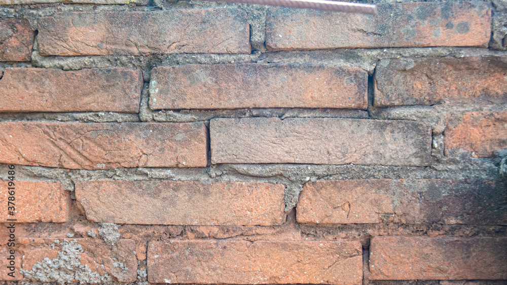 Fototapeta premium Background of an old wall with exposed bricks and an old screw.