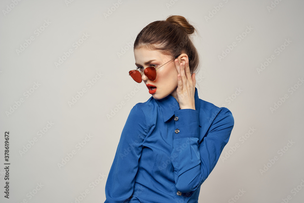 Portrait of a woman in sunglasses and a blue shirt on a light background cropped view of Model Copy Space Portrait of a woman in sunglasses and a blue shirt on a light background cropped view of Model Copy Space