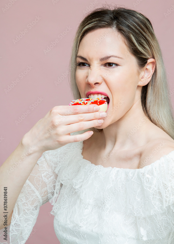 beautiful girl playing with donuts on a pink background. Diet, dieting concept. Junk food, weight loss beautiful girl playing with donuts on a pink background. Diet, dieting concept. Junk food, weight loss
