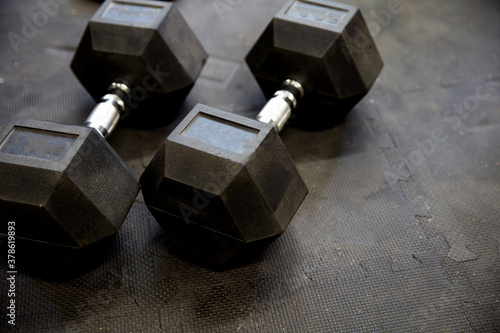 Dumbbells or weights on black rubber flooring tiles inside gym Concept for workout