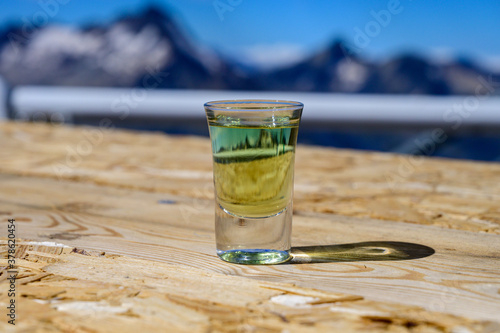 Tasting of very sweet french green strong liqueur based on many herbs, plants and flowers from Chartreuse abbey in Alpine mountains