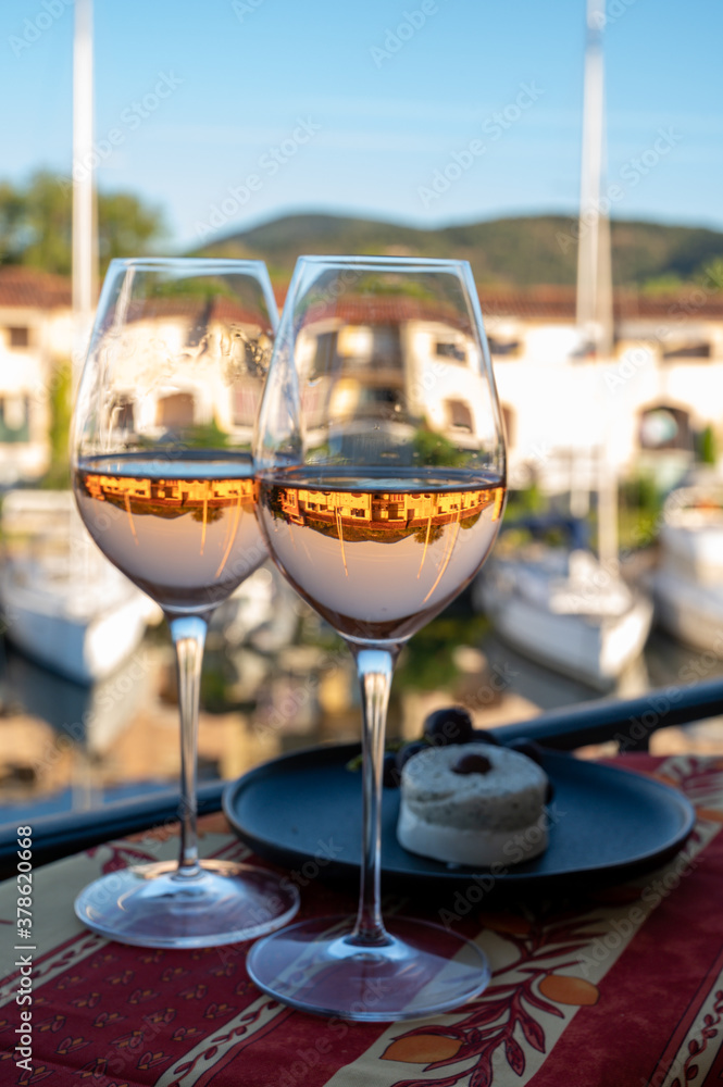 Tasting of local rose wine and soft french goat cheese in summer with sail boats haven of Port Grimaud on background, Provence, France Tasting of local rose wine and soft french goat cheese in summer with sail boats haven of Port Grimaud on background, Provence, France