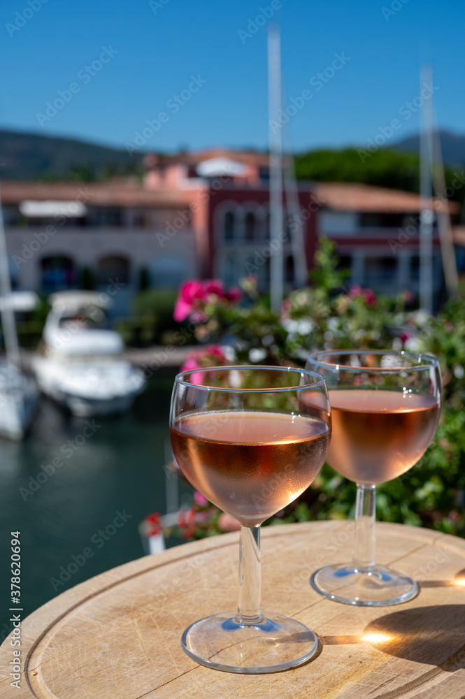 Tasting of local rose wine in summer with sail boats haven of Port Grimaud on background, Provence, France Tasting of local rose wine in summer with sail boats haven of Port Grimaud on background, Provence, France
