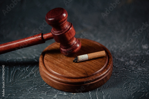 Wooden judge gavel near cigarette. Tobacco law.
