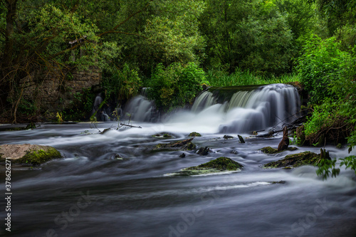 Beautiful waterfall in an abandoned forest on a summer day. photo