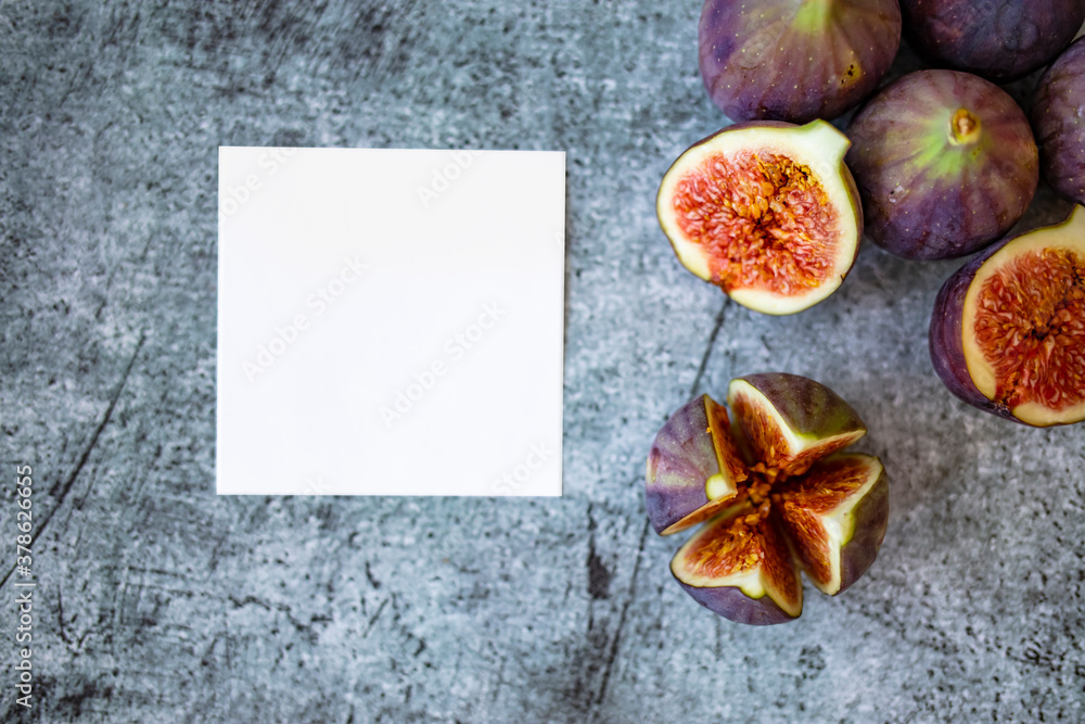 Fresh figs and blank notepad on a white wooden background. Top view, overhead, from above. Space for text. Fresh Organic Figs. Fresh purple fig fruit and slices Fresh figs and blank notepad on a white wooden background. Top view, overhead, from above. Space for text. Fresh Organic Figs. Fresh purple fig fruit and slices