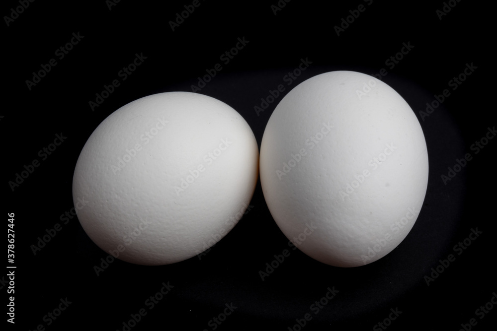 two white eggs isolated on a black background two white eggs isolated on a black background