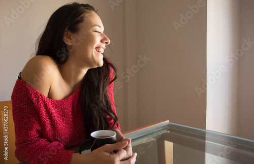 Young woman having brakefast and smiling photo