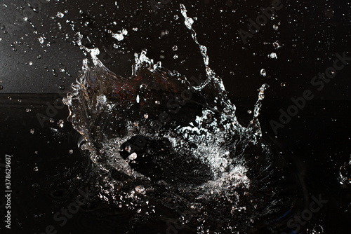 Splash of clear water on black isolated background.