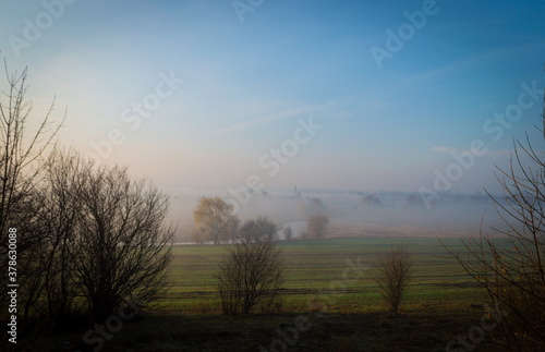 river  under morning fog in the field. river in the field under fog and clear sky.  foggy landscape 