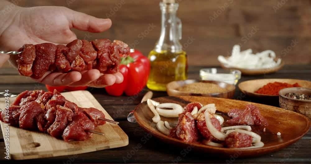 Men's hands incandescent raw pork kebab on a skewer. Men's hands incandescent raw pork kebab on a skewer.