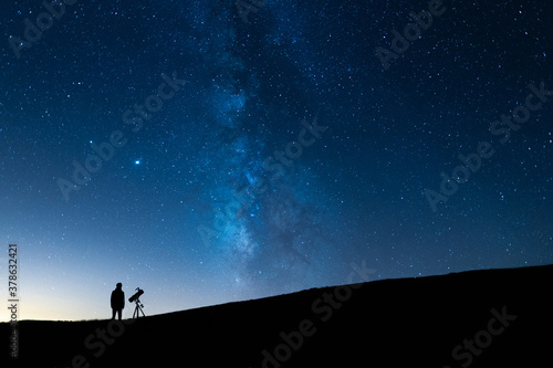 Canvas Person observing the blue starry sky with a telescope at night
